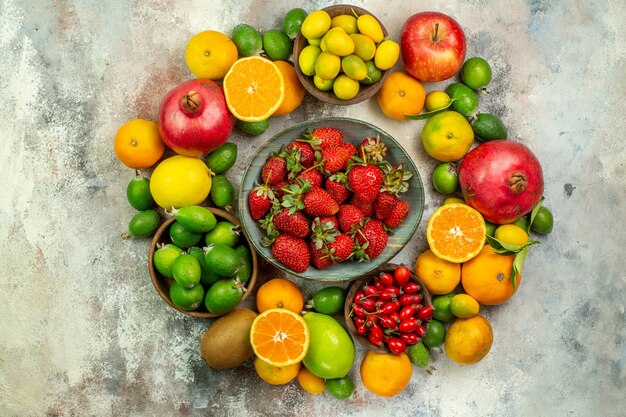 Vista superior de frutas frescas diferentes frutas suaves sobre fondo blanco color de salud sabrosos cítricos de bayas maduras