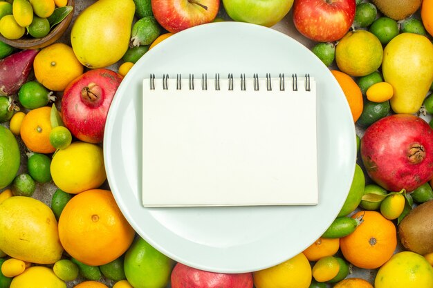 Vista superior de frutas frescas diferentes frutas suaves sobre fondo blanco dieta de bayas maduras salud de árbol de color sabroso