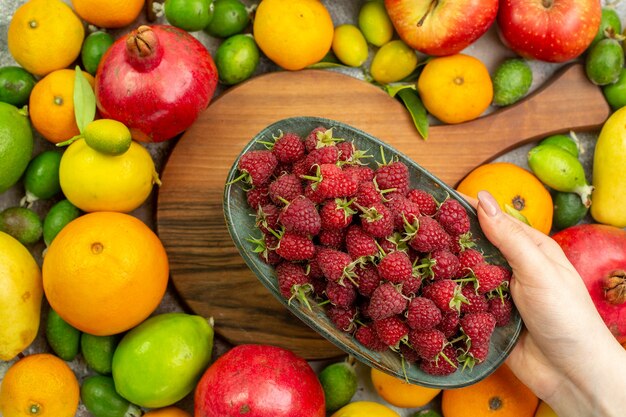 Vista superior de frutas frescas diferentes maduras y suaves en el escritorio blanco