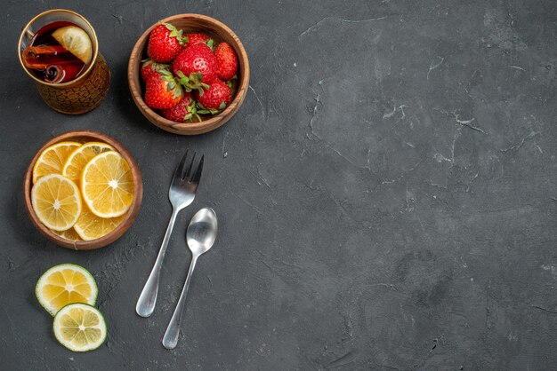 Vista superior de frutas frescas fresas y limones en la superficie gris