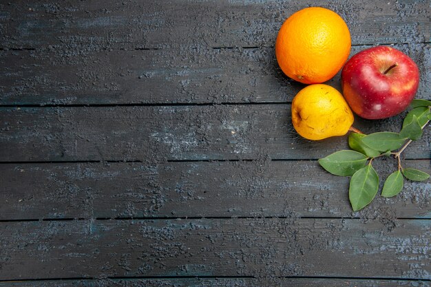 Vista superior de frutas frescas manzana pera y naranja en la mesa oscura fruta fresca madura suave