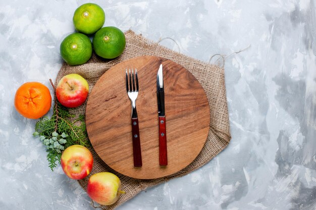 Vista superior de frutas frescas, manzanas y mandarinas en un escritorio blanco claro