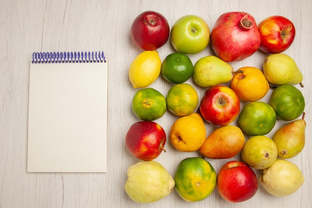 Vista superior de frutas frescas, manzanas, mandarinas, peras y otras frutas en el escritorio blanco frutas árbol maduro suave muchos frescos