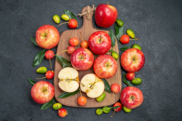 Vista superior de frutas lejanas las apetitosas cerezas manzanas en el tablero junto a los cítricos