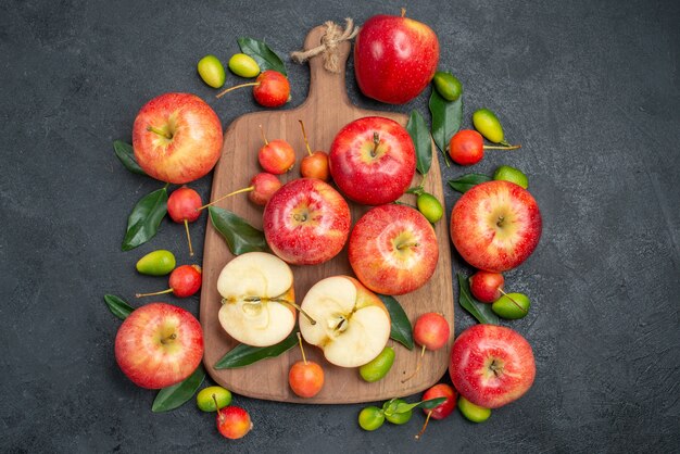 Vista superior de frutas lejanas las apetitosas cerezas manzanas en el tablero junto a los cítricos