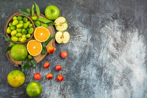 Vista superior de frutas lejanas las apetitosas manzanas cítricos en las cerezas de la tabla de cortar