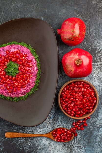 Vista superior de frutas lejanas semillas de granada cuchara un plato apetitoso