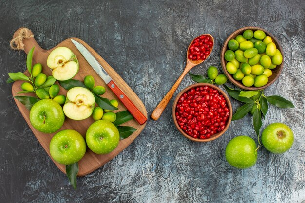 Vista superior frutas manzanas cítricos semillas de granadas tablero con cuchillo de manzanas