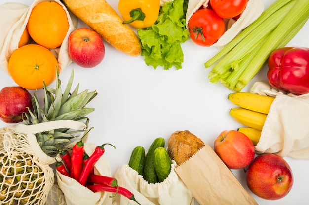 Vista superior de frutas y verduras en bolsas reutilizables.
