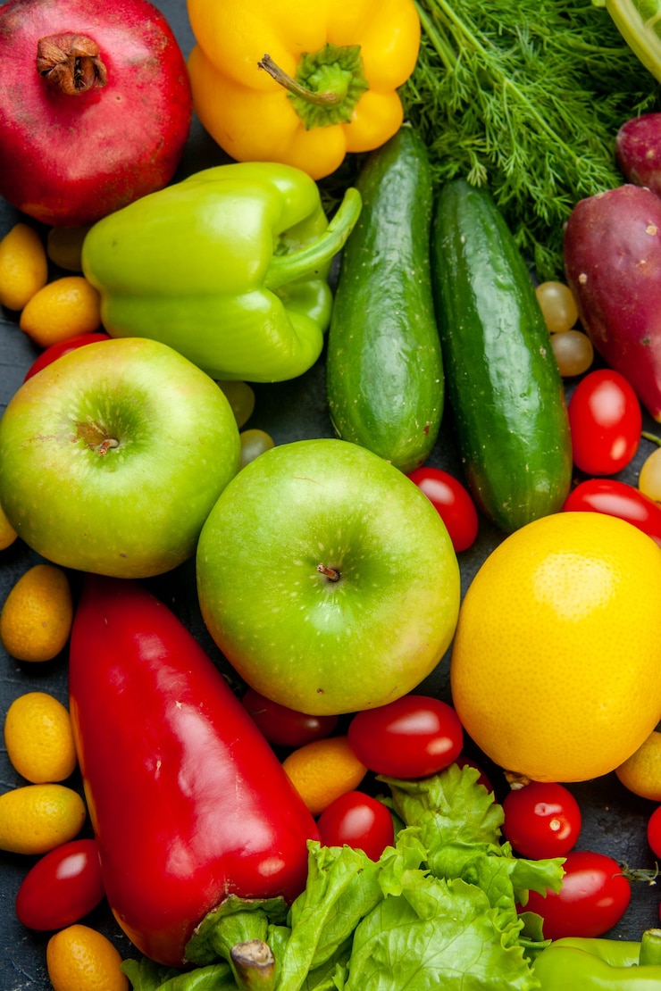 Foto gratuito vista superior de frutas y verduras lechuga pepinos pimientos granada eneldo tomates cherry cumcuat