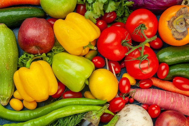 Vista superior frutas y verduras pimientos manzanas zanahoria cilantro coliflor caqui rábano tomates cherry repollo rojo tomates pimiento verde