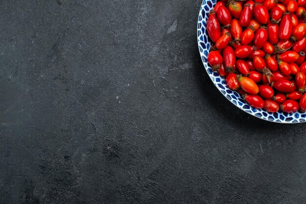 Vista superior de frutos rojos maduros y bayas agrias en el interior de la superficie gris