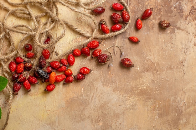 Vista superior de frutos rojos secos con cuerdas en el escritorio de madera frutos rojos baya