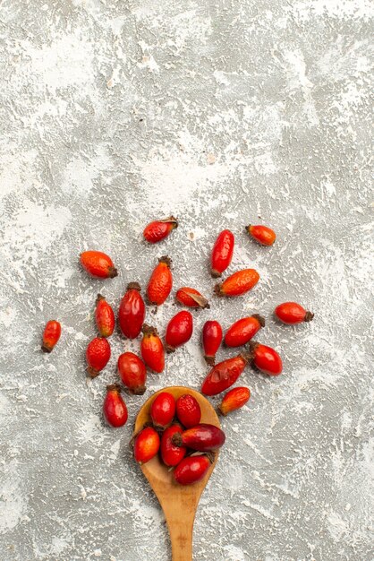 Vista superior de frutos rojos secos en superficie blanca color seco de frutas