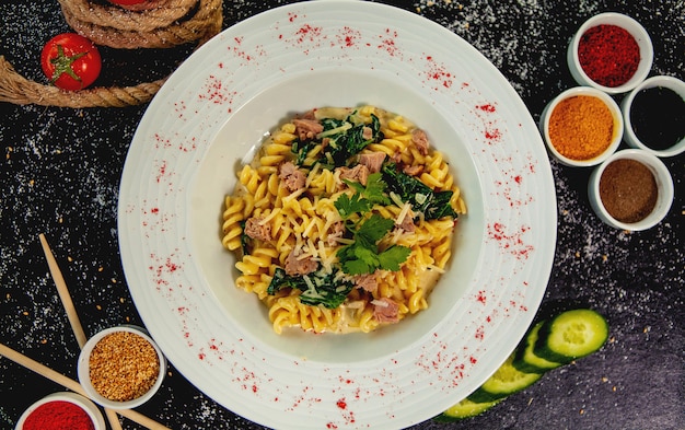 Vista superior de fusilli de atún con espinacas y parmesano