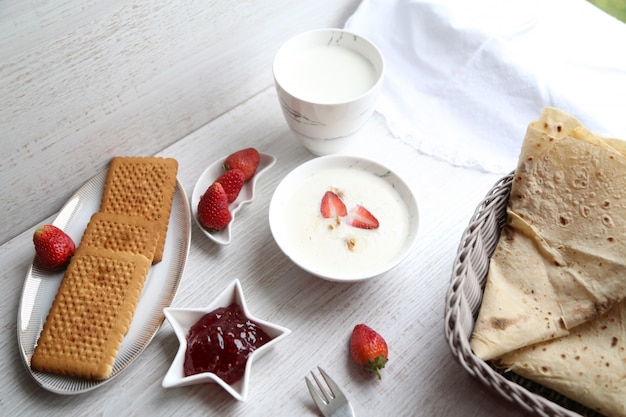 Vista superior de gachas de arroz con leche y pajitas servidas con mermelada y galletas en blanco