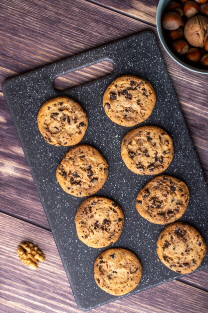 Vista superior de galletas de avena con chocolate en un tablero con nueces