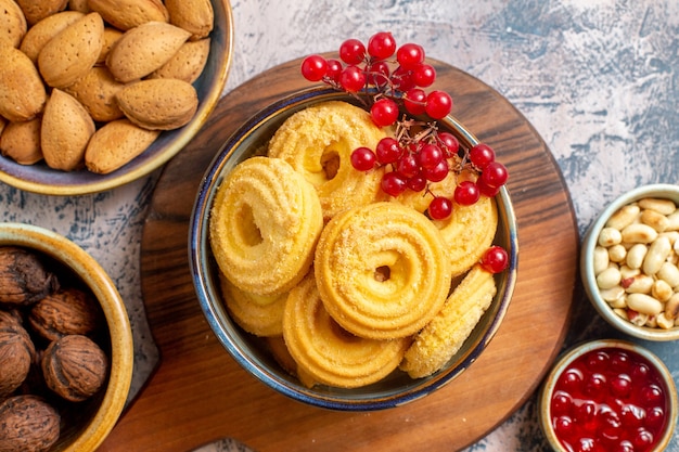 Vista superior de galletas de azúcar con diferentes frutos secos en superficie azul