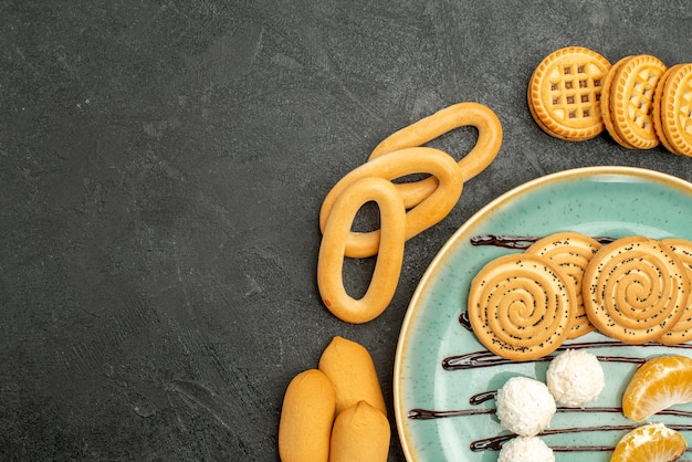 Vista superior de las galletas de azúcar con galletas y dulces en el escritorio gris