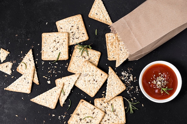 Vista superior de galletas con bolsa de papel y salsa de tomate