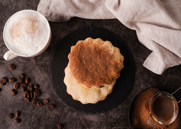 Vista superior de galletas con cacao en polvo en la parte superior y la taza