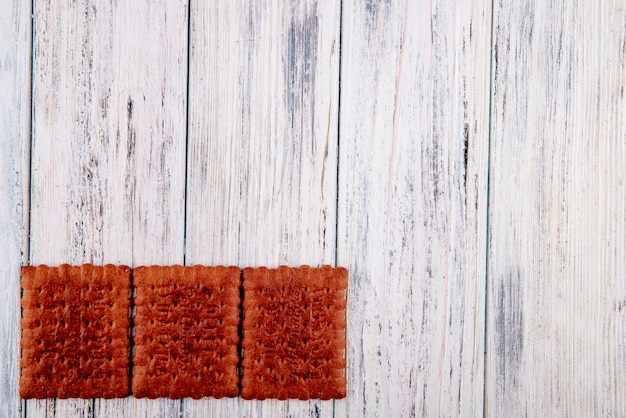 Vista superior Galletas de chocolate a la izquierda con espacio de copia sobre fondo blanco de madera