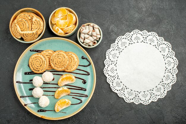 Vista superior de galletas dulces con caramelos de coco sobre fondo gris