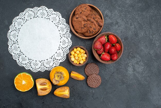 Vista superior de galletas dulces con frutas en la mesa oscura galleta dulce