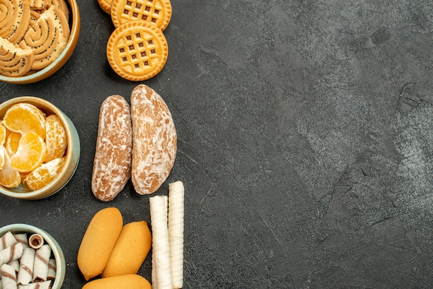 Vista superior de galletas dulces con galletas y frutas sobre fondo gris