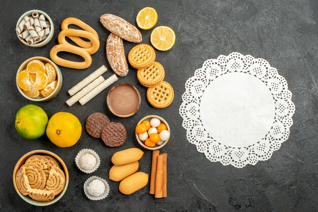 Vista superior de galletas dulces con galletas y frutas sobre fondo gris