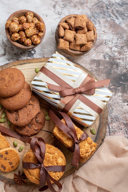 Vista superior de galletas dulces con nueces y regalos en mesa de luz
