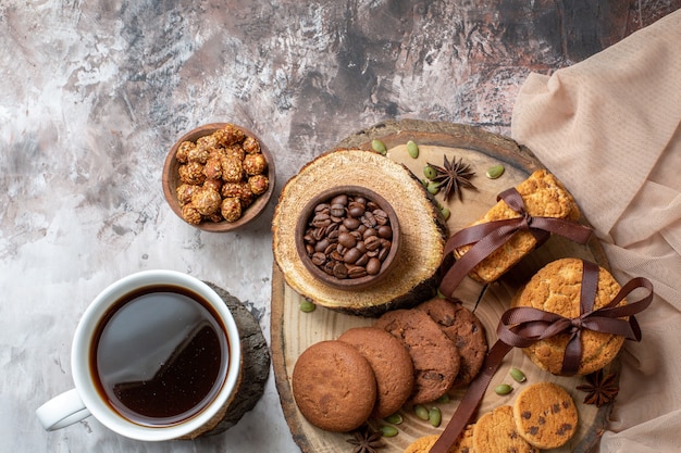Vista superior de galletas dulces con nueces y una taza de café en la mesa de luz