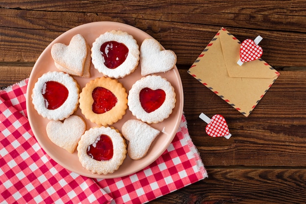 Vista superior de galletas en forma de corazón en un plato con mermelada