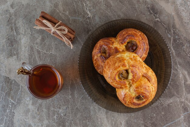 Vista superior de galletas frescas caseras con taza de té en gris.