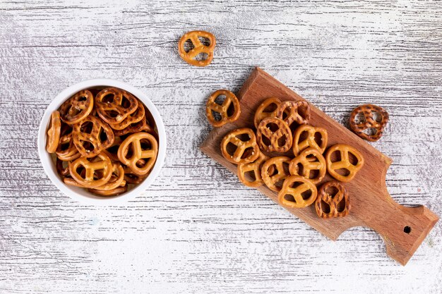 Foto gratuita vista superior de galletas en el tablero de madera y en un tazón de madera blanca horizontal