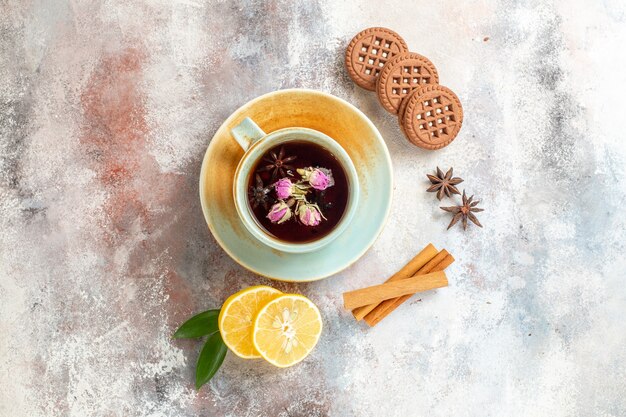 Vista superior de galletas de té de hierbas y rodajas de limón limón canela sobre fondo blanco.