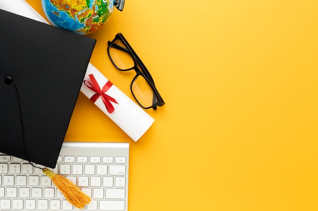 Foto gratuita vista superior de gorra académica y gafas con teclado