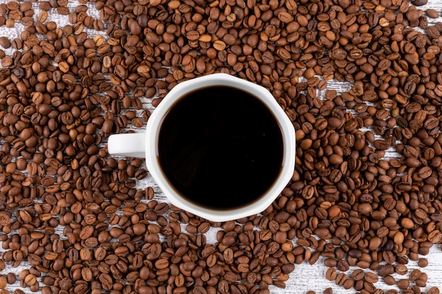 Vista superior de granos de café con superficie de taza de café