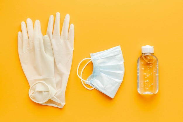 Vista superior de guantes con mascarilla médica y desinfectante para manos