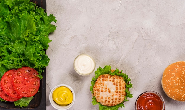 Vista superior hamburguesa clásica con rodajas de tomate y salsa