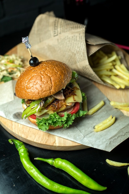 Vista superior hamburguesa con papas fritas y pimiento verde en pizarra