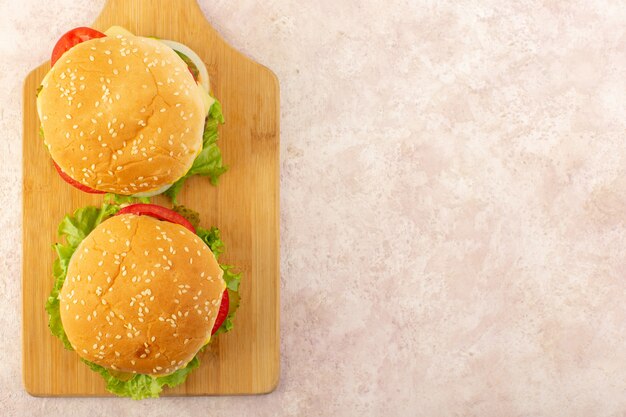 Una vista superior de hamburguesas de carne con verduras y ensalada verde.