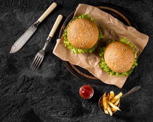 Vista superior de hamburguesas y papas fritas con salsa