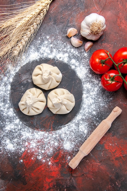 Foto gratuita vista superior de harina de ajo rodillo de amasar tomates de harina khinkali con pedicelos