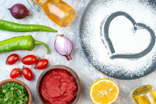 Vista superior de harina blanca en forma de corazón con verduras frescas en la mesa blanca pastel de color pastel de pizza dieta salud