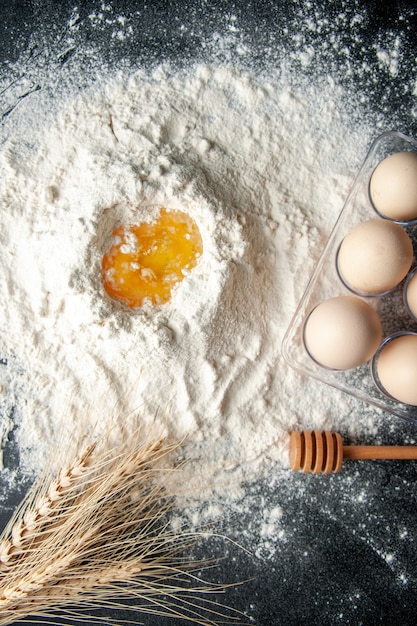 Foto gratuita vista superior de harina blanca mezclada con huevo sobre fondo oscuro trabajo de pastelería pastel de huevo cocina de trabajador de panadería