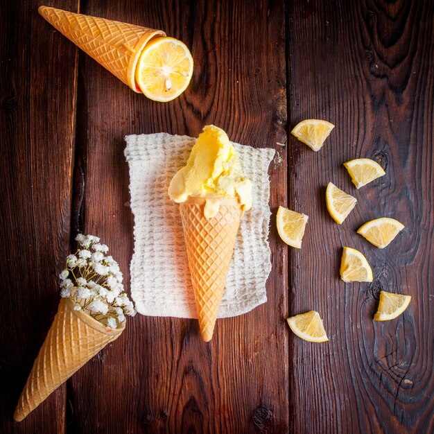 Vista superior de helado en un cono de waffle con naranja y gypsophila en servilletas de trapo