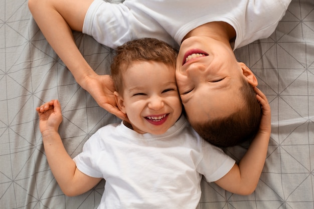 Foto gratuita vista superior hermanos acostados en la cama