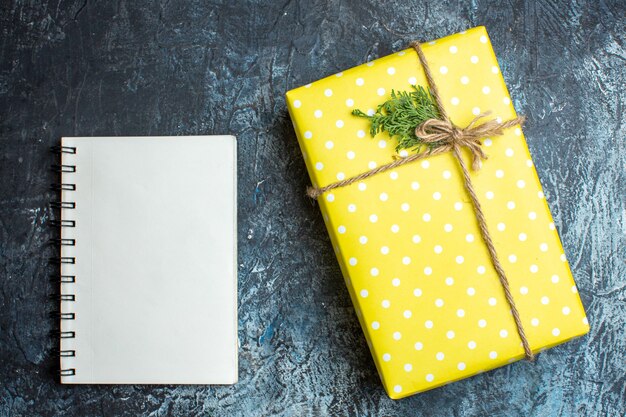 Vista superior de la hermosa caja de regalo de Navidad para miembros de la familia y portátil sobre fondo oscuro