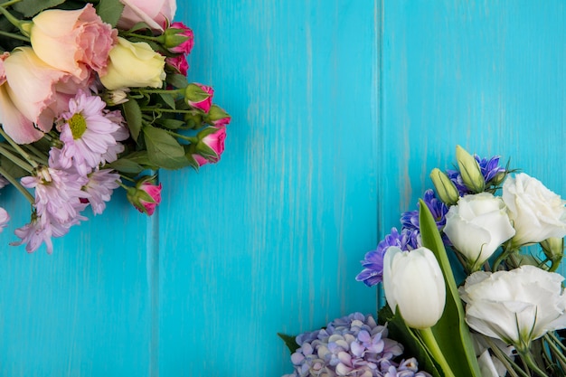Vista superior de hermosas flores de colores como tulipán rosa lila con hojas sobre un fondo azul con espacio de copia